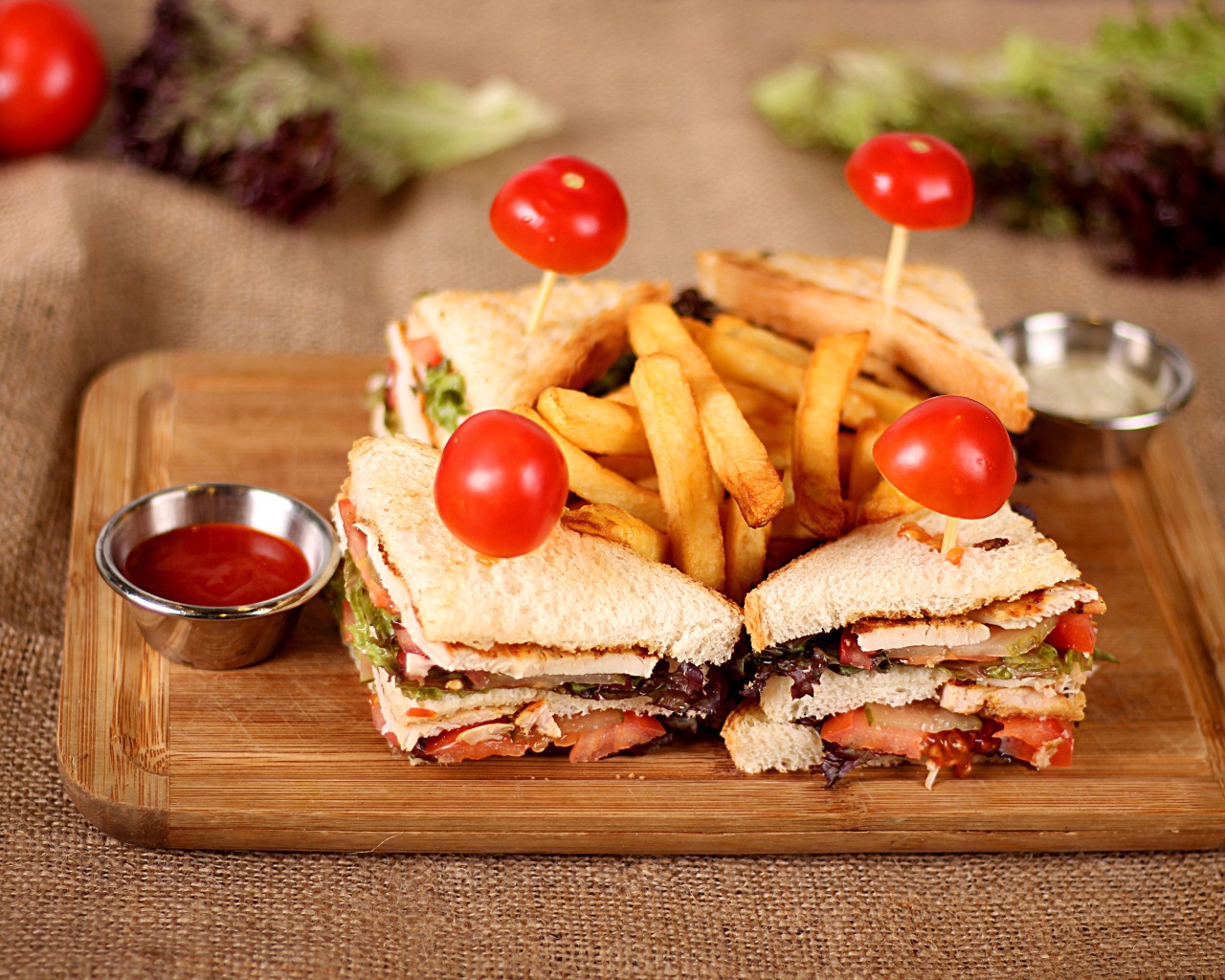 Сэндвичи на доске с картофелем фри и соусом