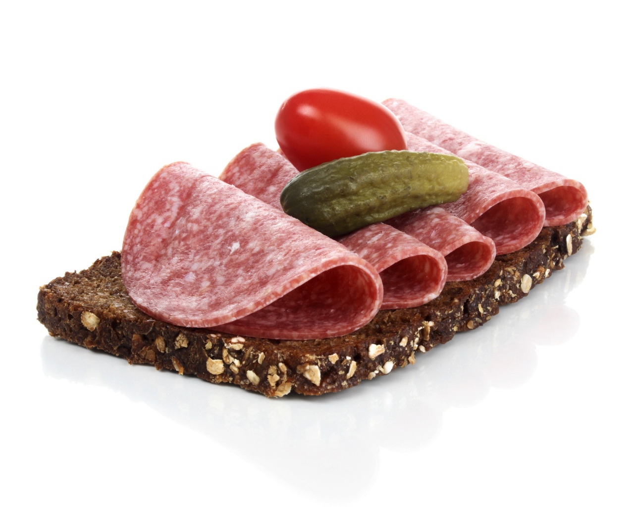 Бутерброд с черным хлебом, колбасой, соленым огурцом и помидором на белом фоне