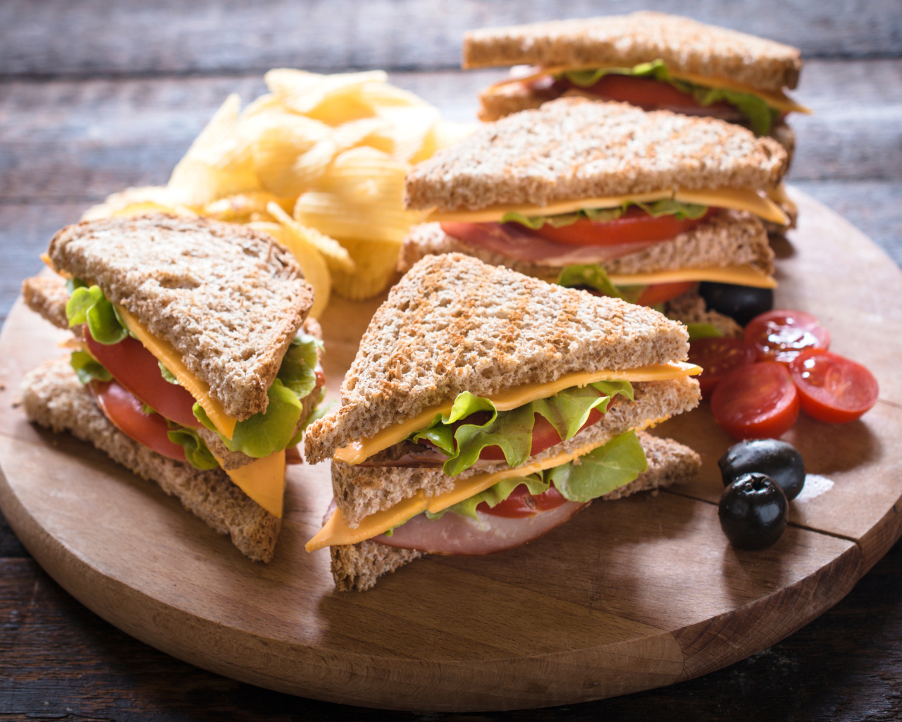 Сэндвичи на деревянной доске с оливками