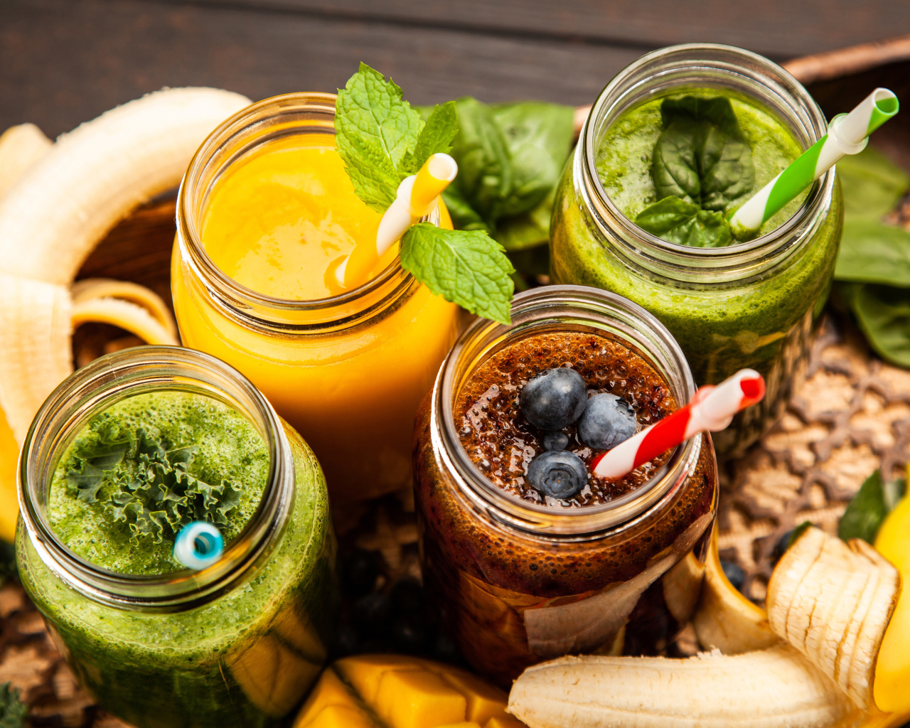 Банки со смузи на столе с бананами