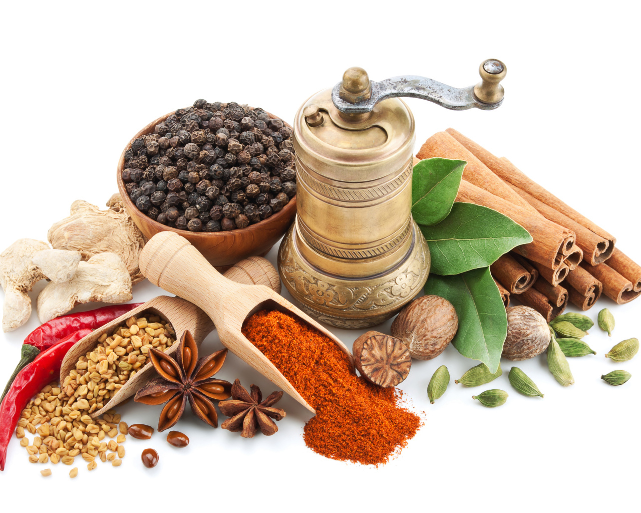Пряные специи на столе с мельницей на белом фоне