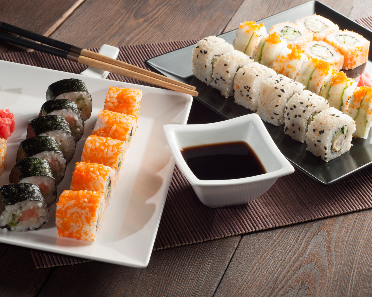 Суши на столе с соевым соусом и палочками