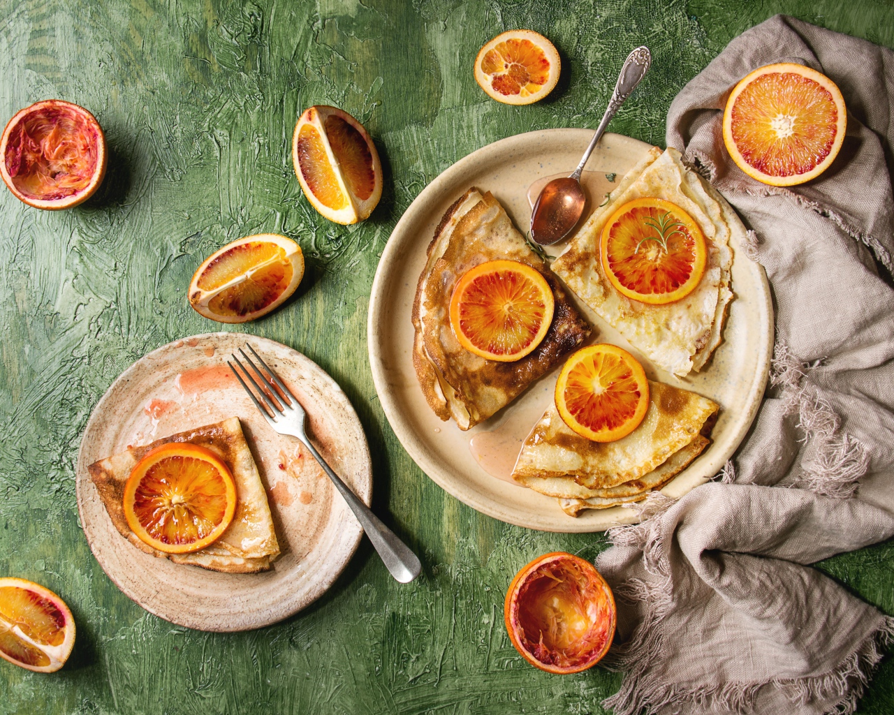 Тонкие блинчики с апельсинами на столе