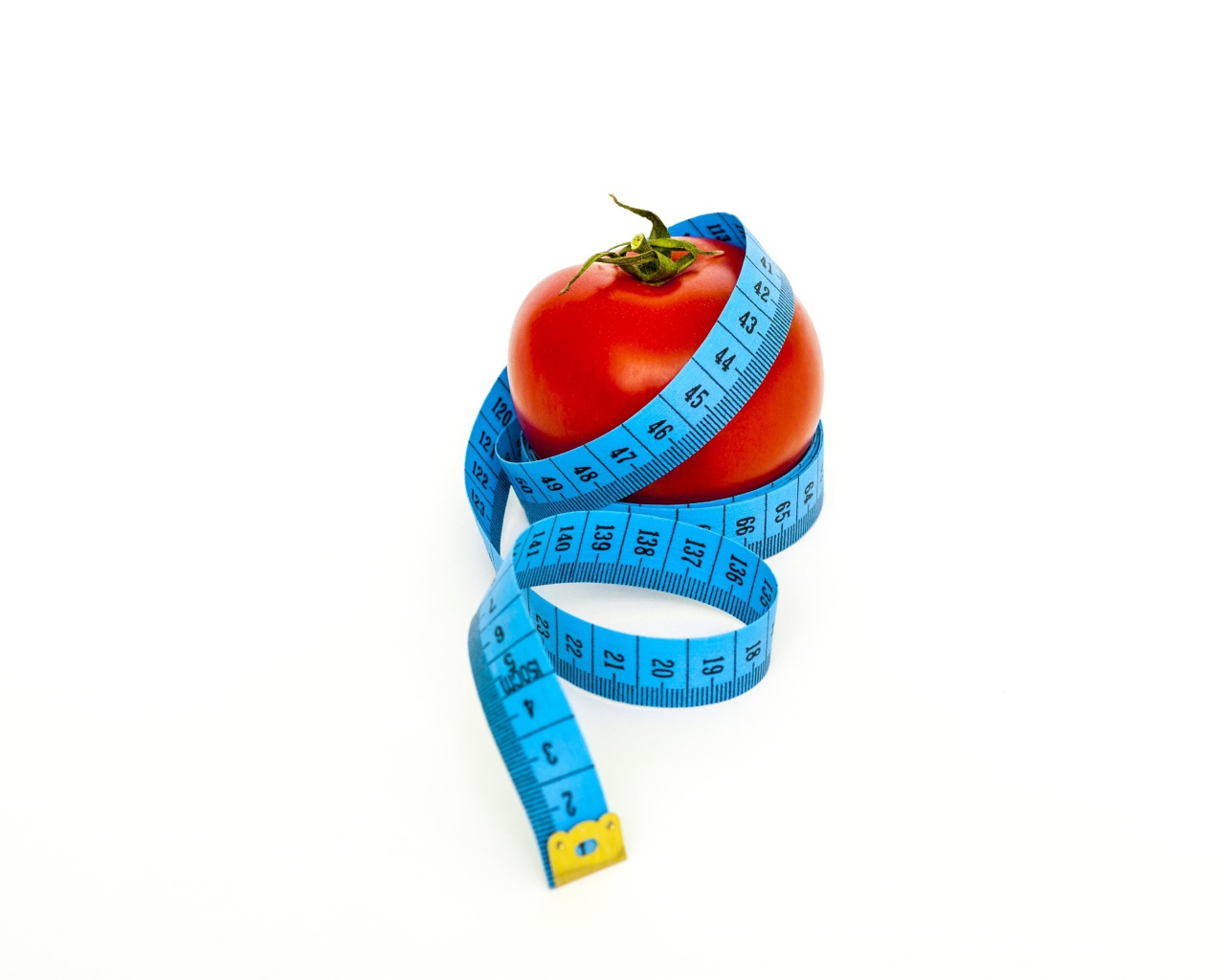 Помидор с голубым сантиметром на белом фоне