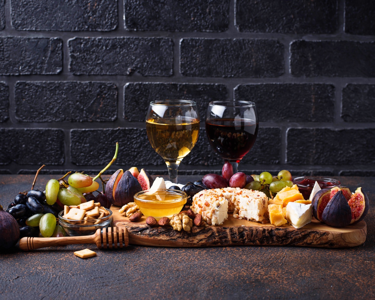 Два бокала вина на столе с сыром, инжиром и виноградом