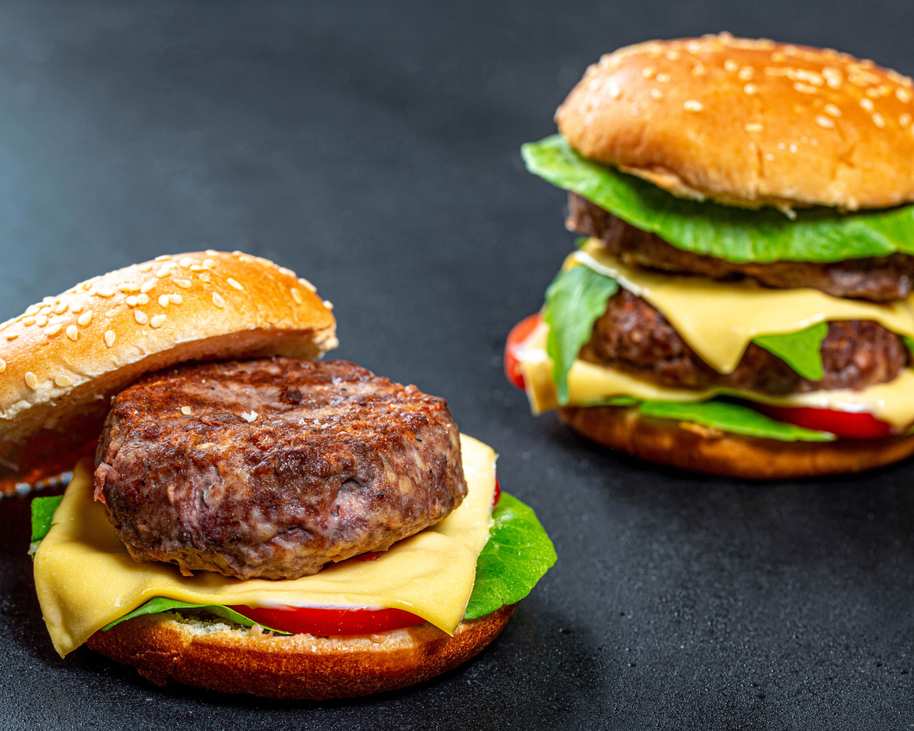 Два гамбургера с большой котлетой на столе