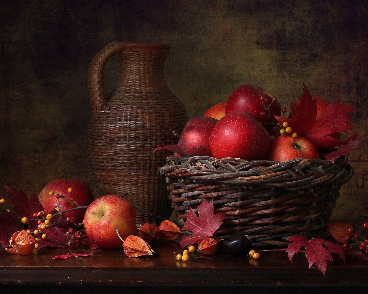 Корзина с красными яблоками на столе с кувшином 