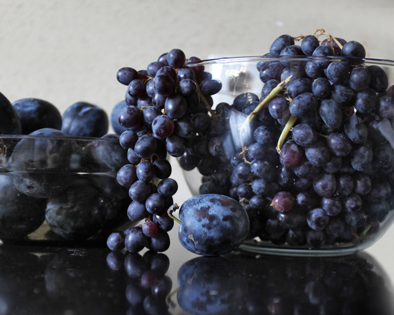 Синий виноград с синими сливами на столе