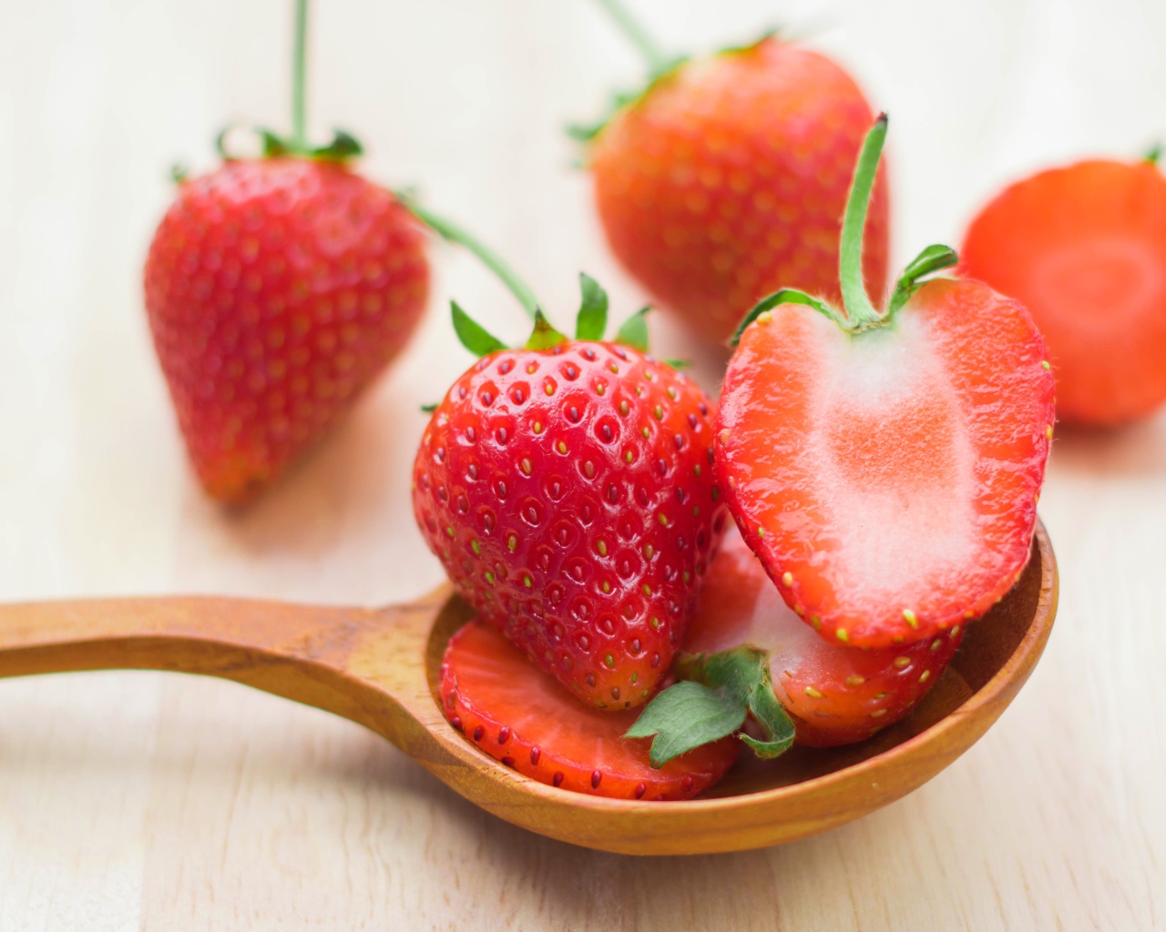 Свежая красная клубника лежит на деревянной ложке