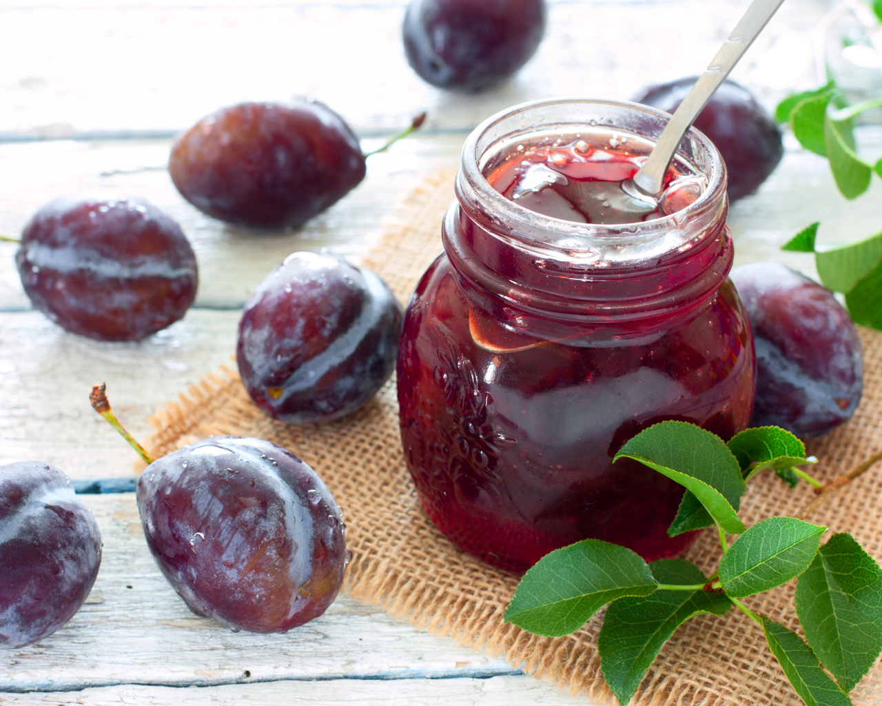 Джем в банке на столе со сливами