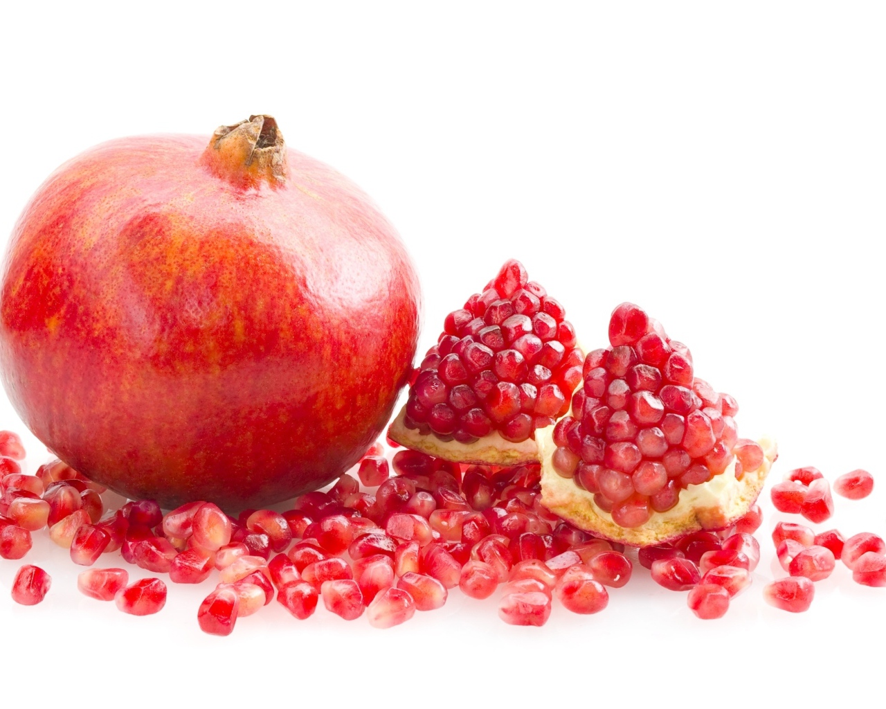 Красный гранат с зернами на белом фоне