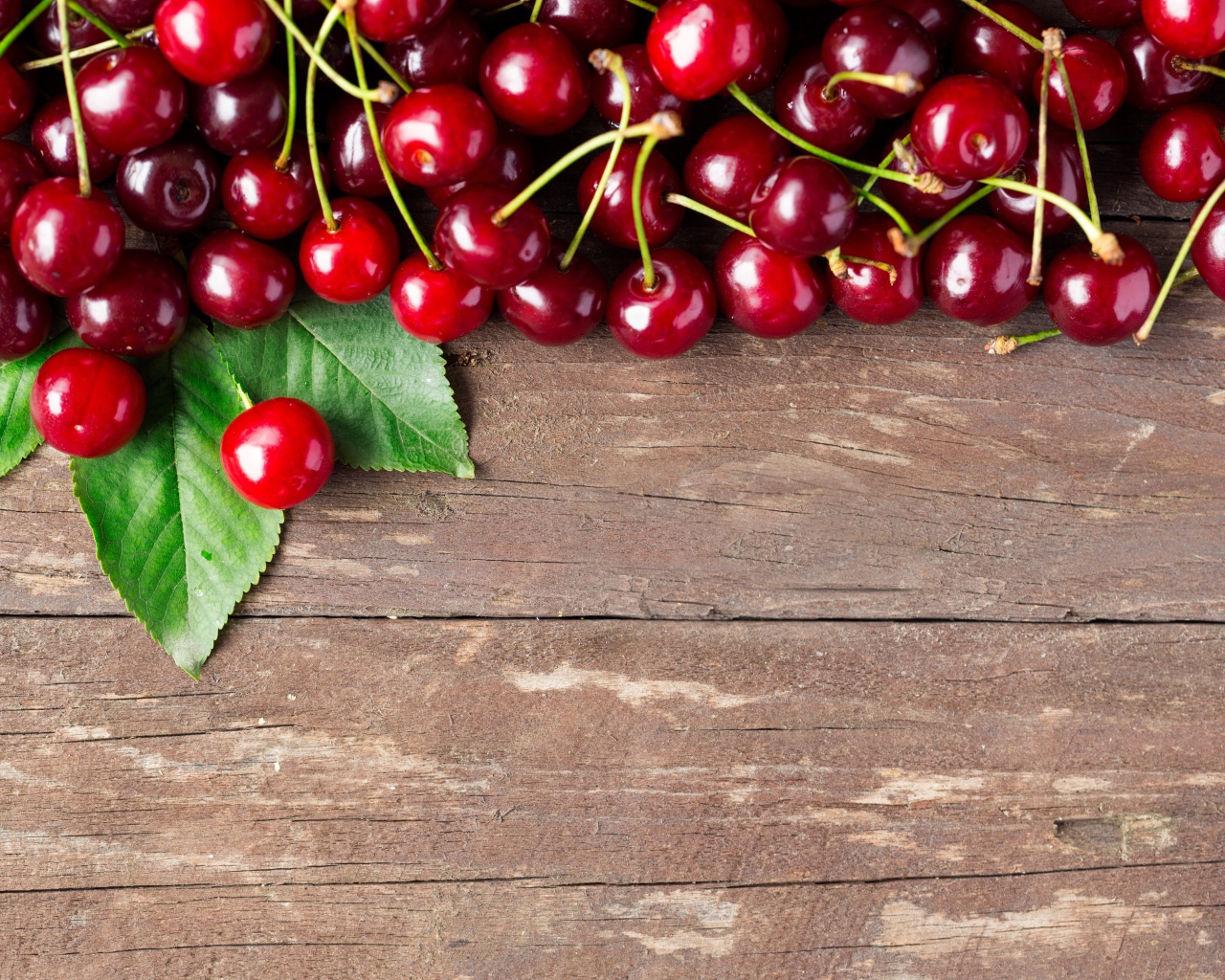 Красные спелые вишни на деревянном столе