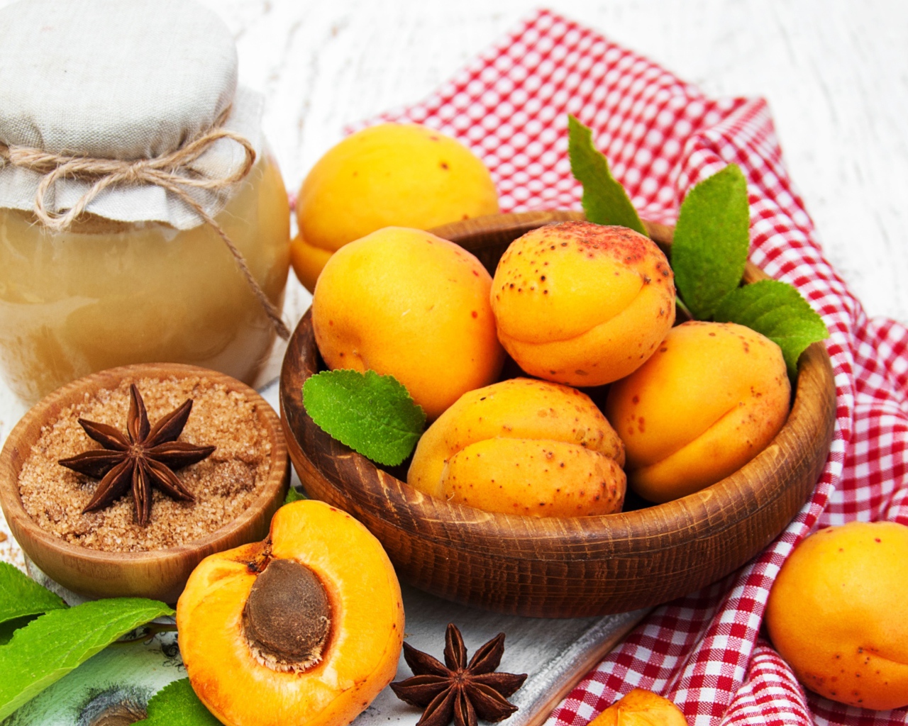 Спелые абрикосы на столе с бадьяном, коричневым сахаром и джемом