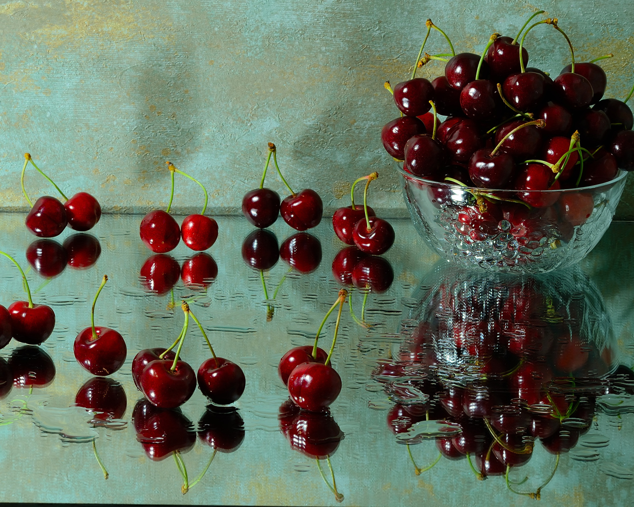 Спелые красные черешни отражаются в поверхности стола