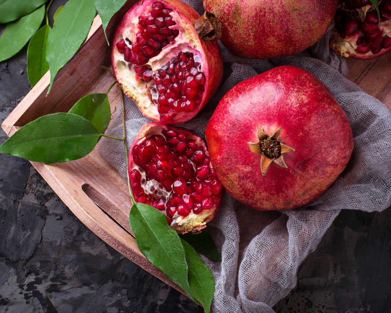 Спелые красные гранаты в деревянном ящике