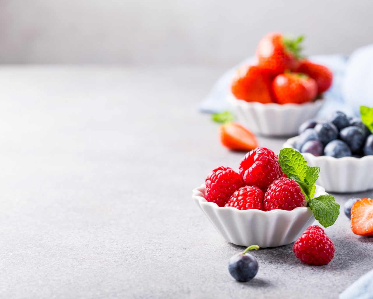 Ягоды клубники, малины и черники на столе 