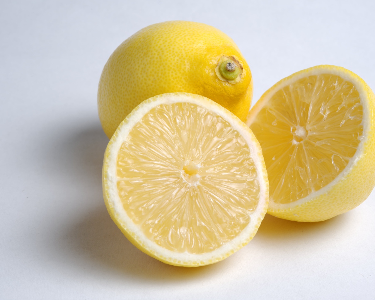 Желтые кислые лимоны на сером фоне