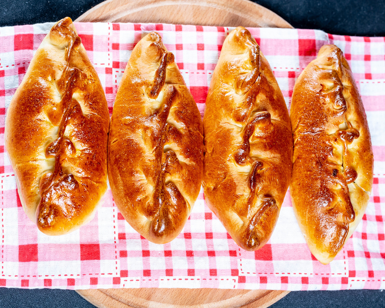 Аппетитные румяные пирожки лежат на полотенце 