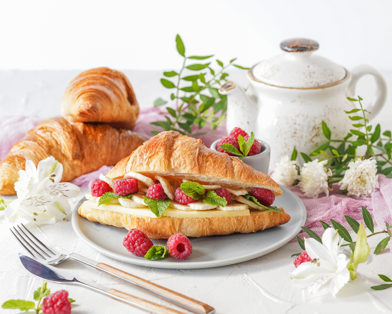 Бутерброд из круассана с ягодами малины и бананами