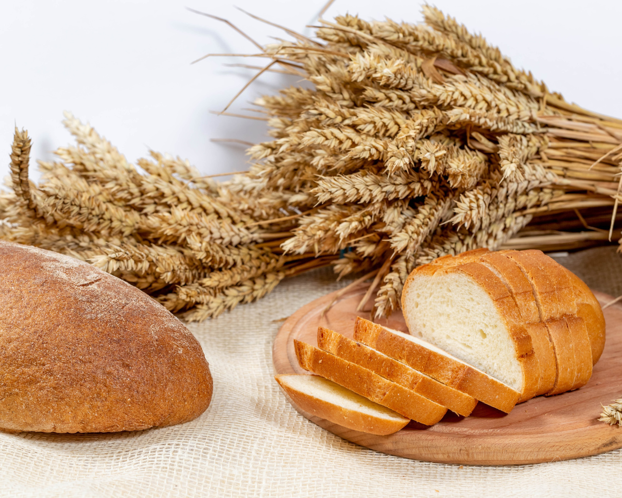 Свежий ароматный хлеб на столе с колосьями пшеницы