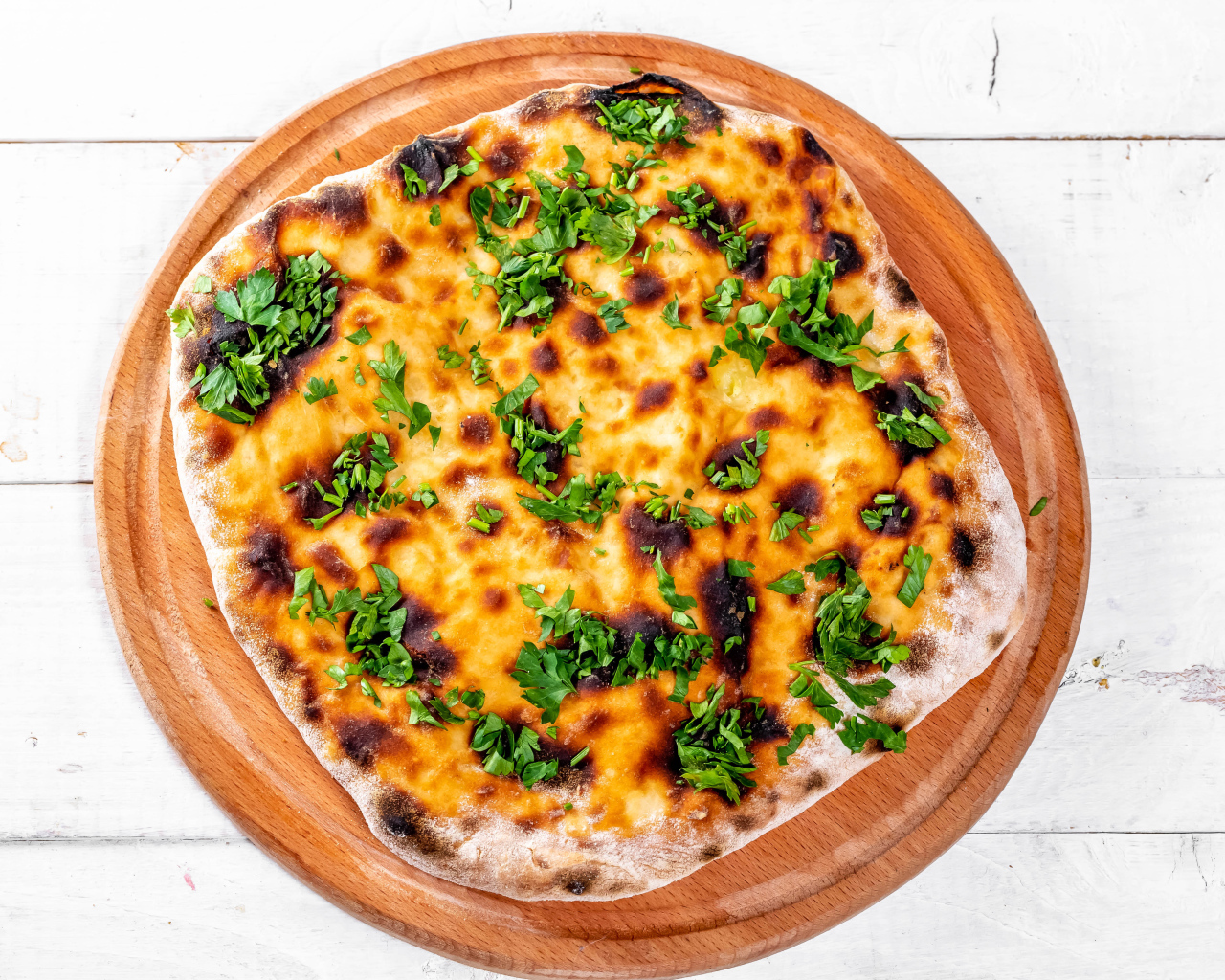 Пирог с сыром и зеленью на доске 