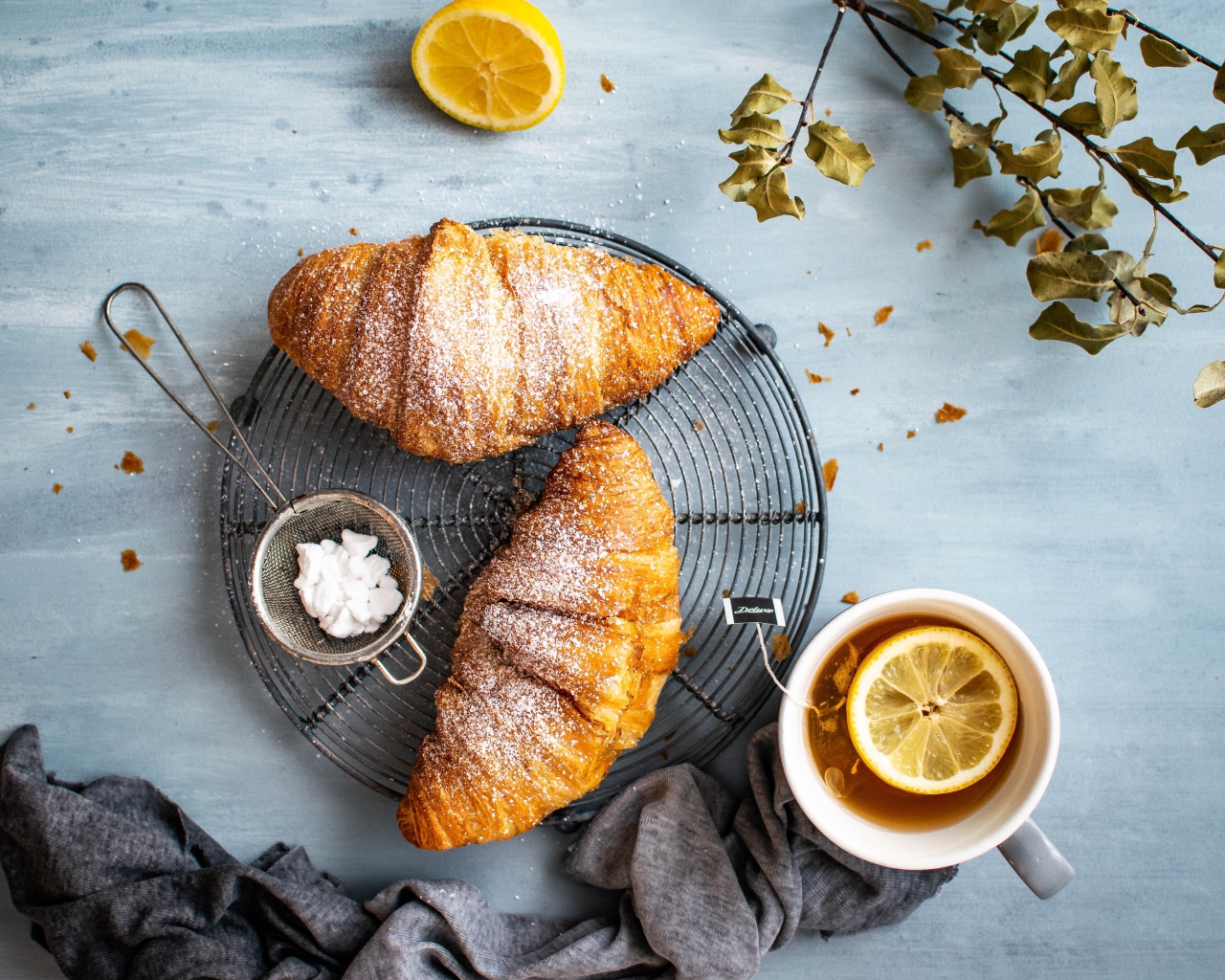 Два свежих круассана на столе с чаем