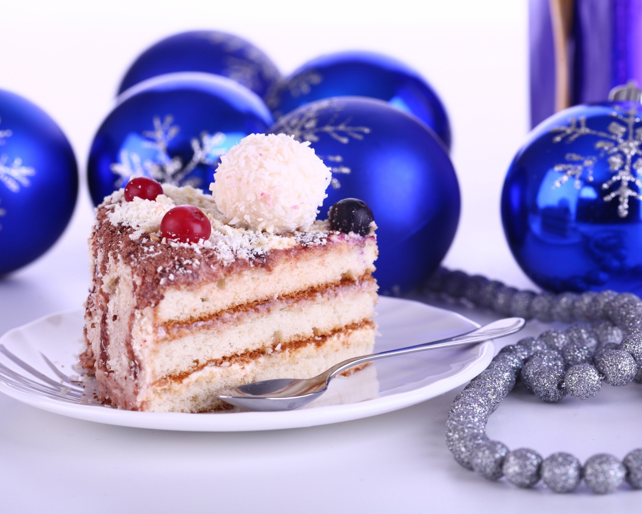Кусок торта на тарелке на столе с елочными украшениями