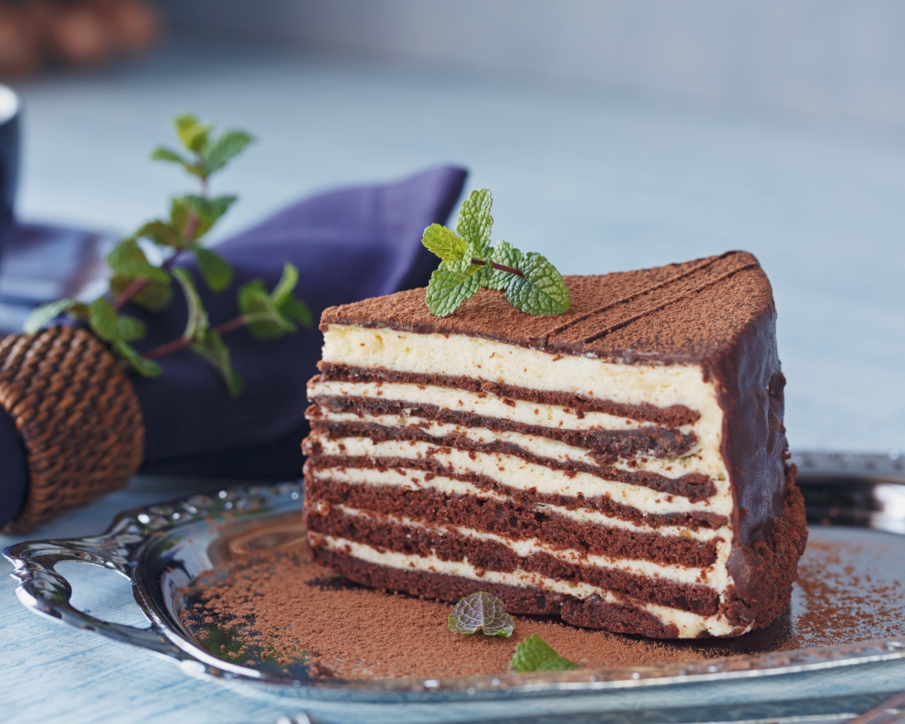 Кусок торта с кремом и какао на блюде 