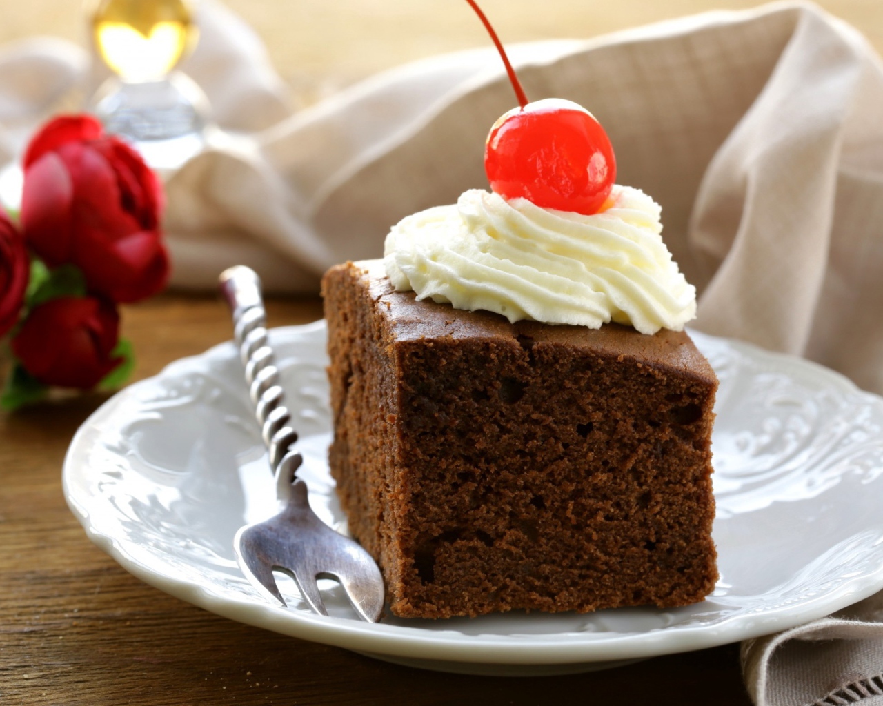 Кусок шоколадного пирога с кремом и вишней 