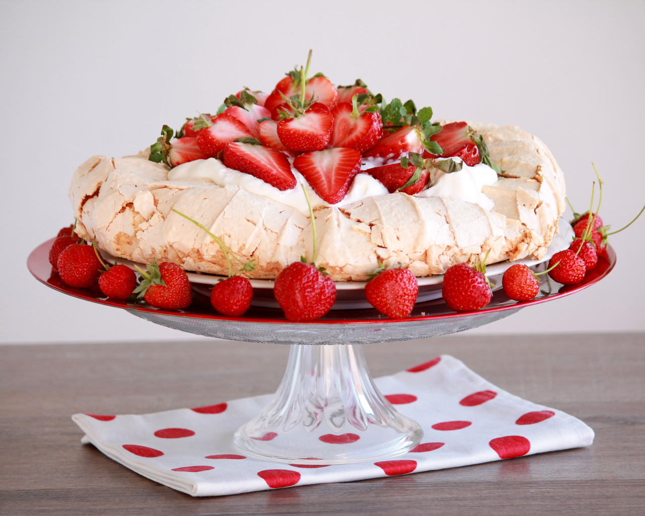 Аппетитный десерт Павлова на блюде с клубникой