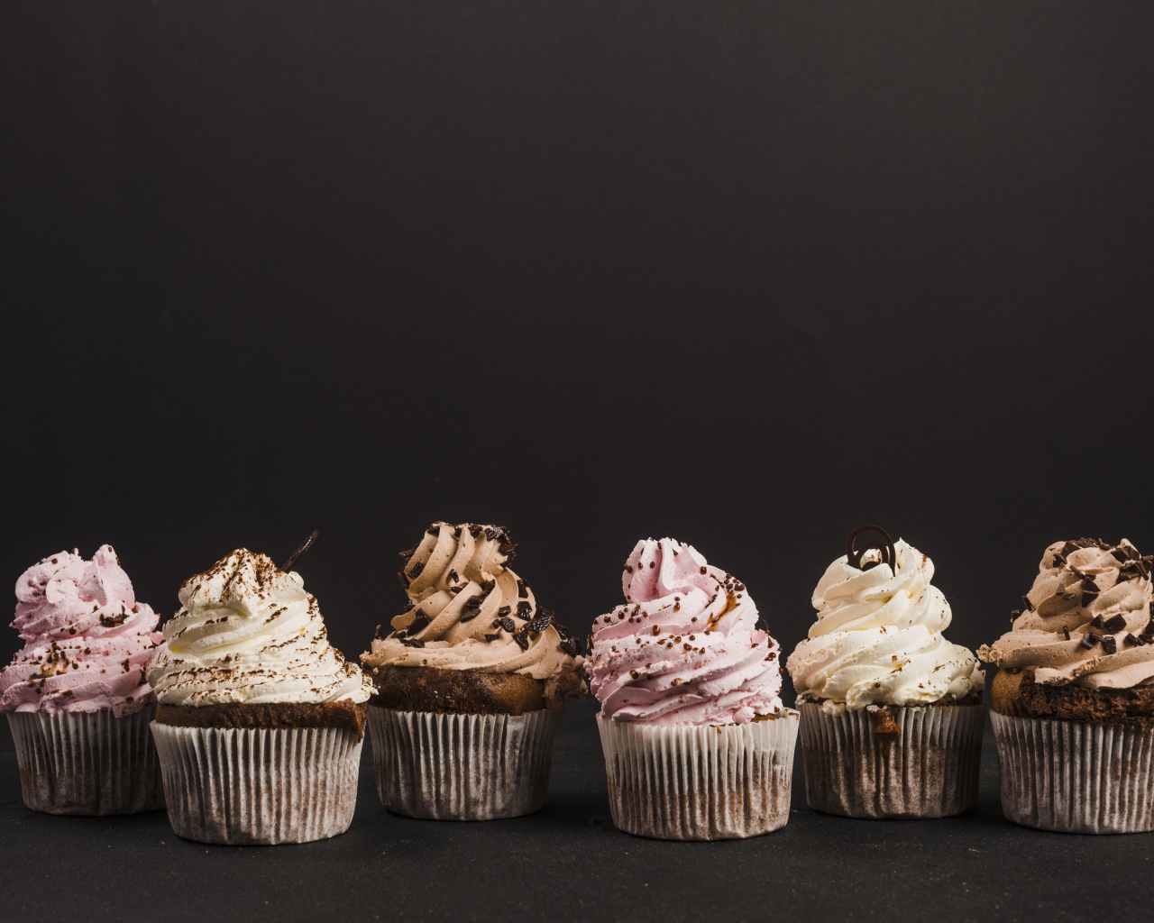 Аппетитные кексы с кремом на сером фоне