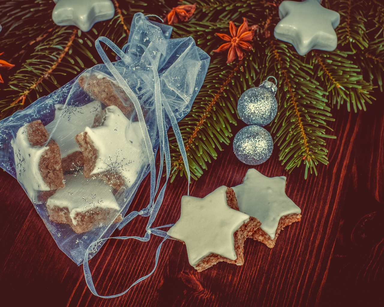 Аппетитное печенье звездочки в мешочке на столе с еловой веткой