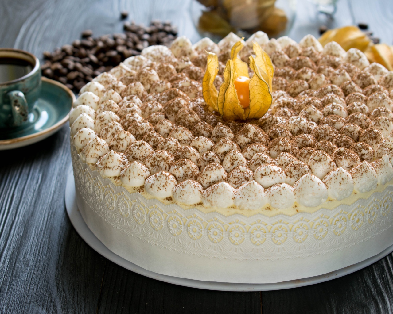 Красивый праздничный торт с цветком физалиса на столе с кофе