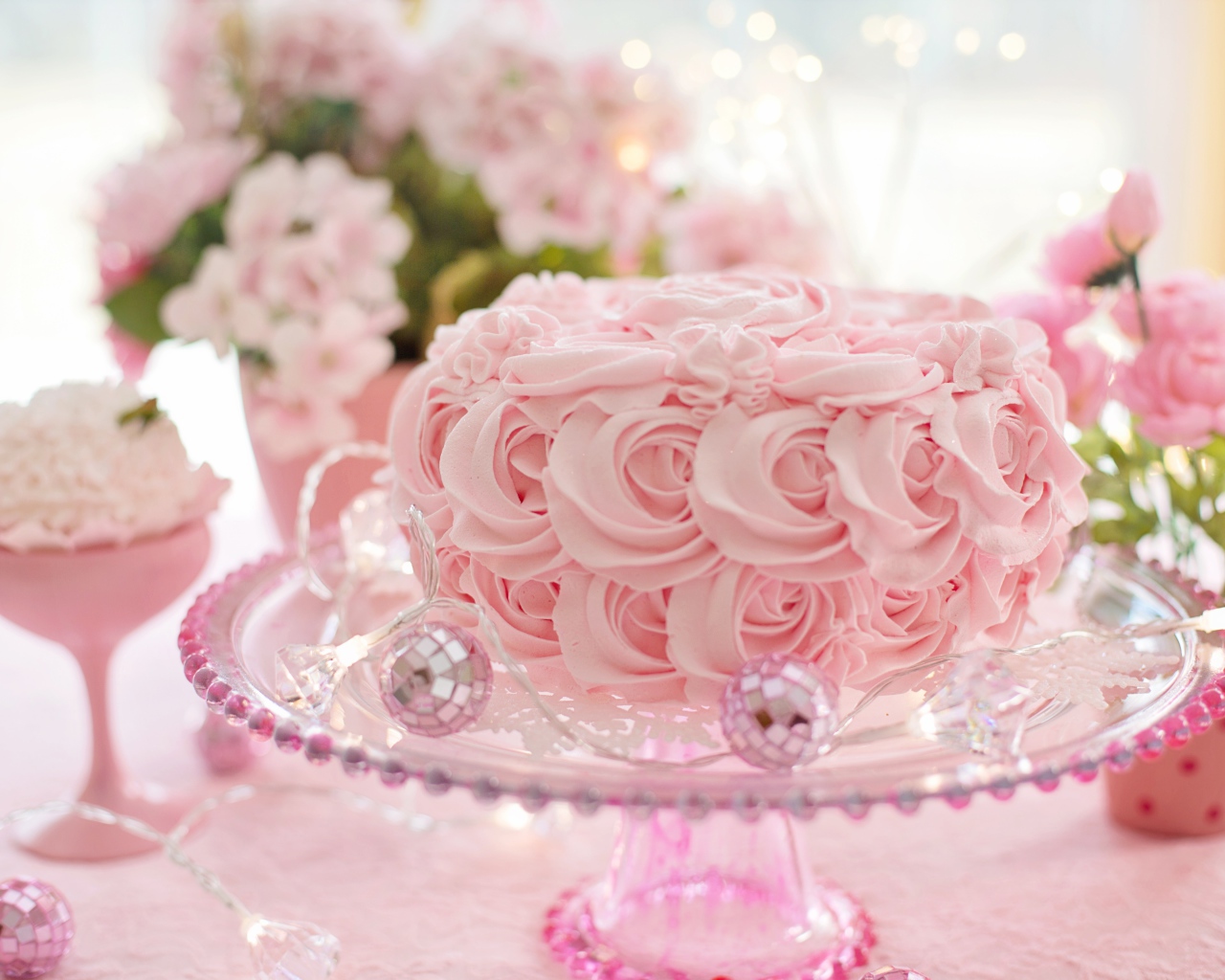 Красивый розовый торт на столе с цветами