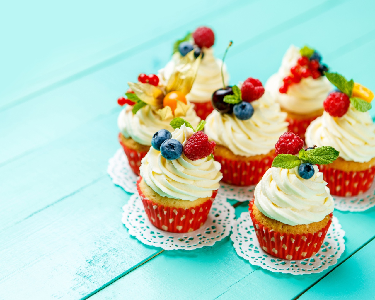 Кексы со взбитыми сливками украшены ягодами