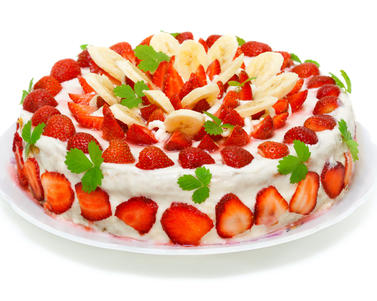 Большой торт с клубникой и бананами на белом фоне