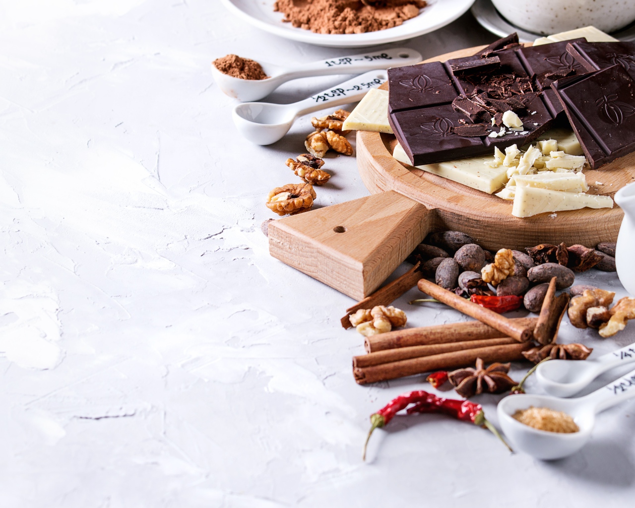 Черный и молочный шоколад на столе с орехами