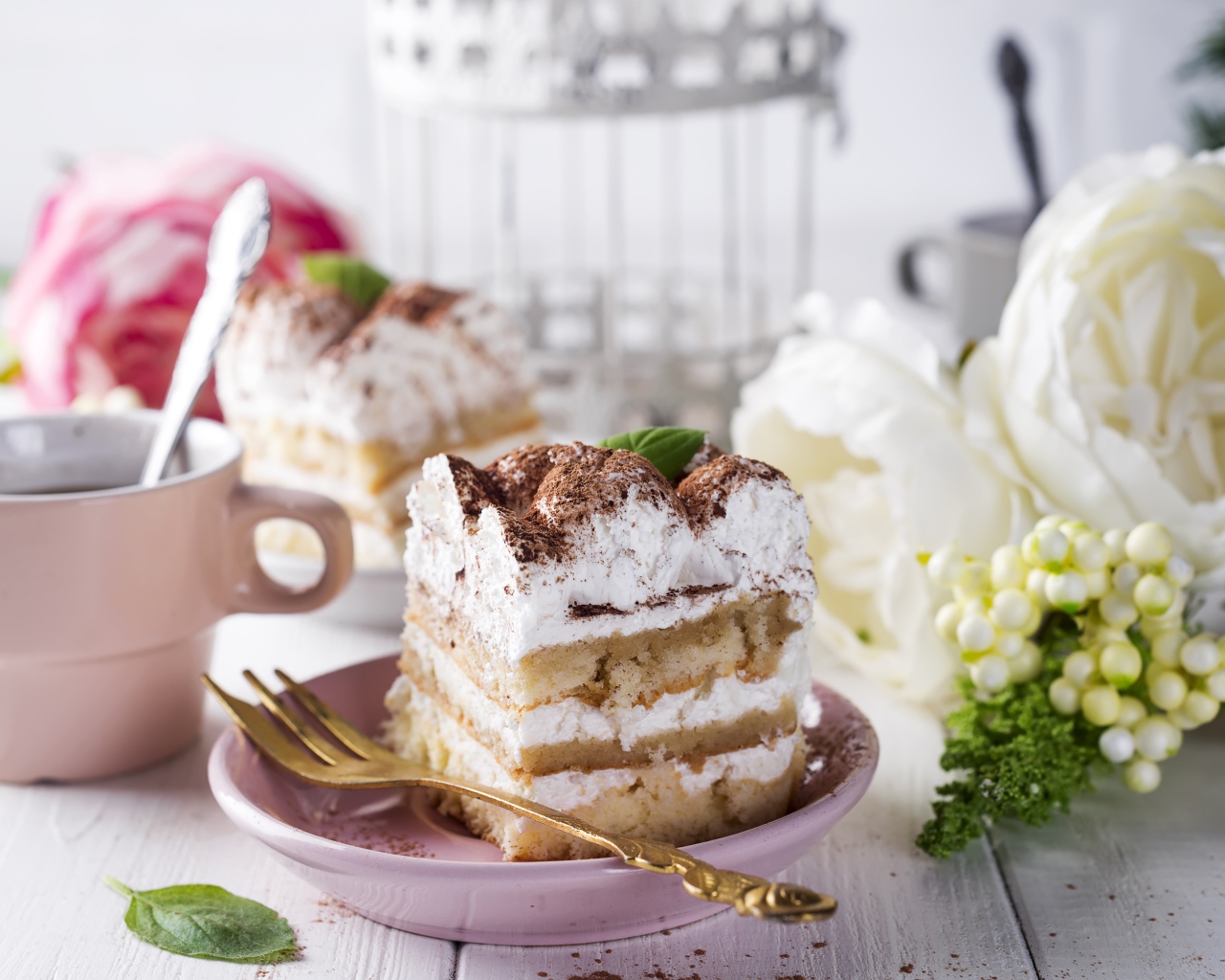 Пирожное на столе с кофе и цветами 