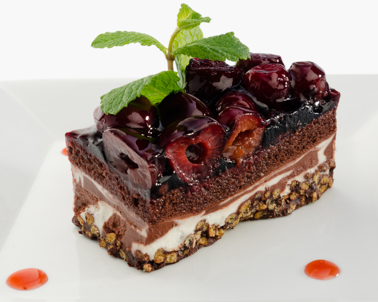 Пирожное с черешней и листиками мяты на сером фоне