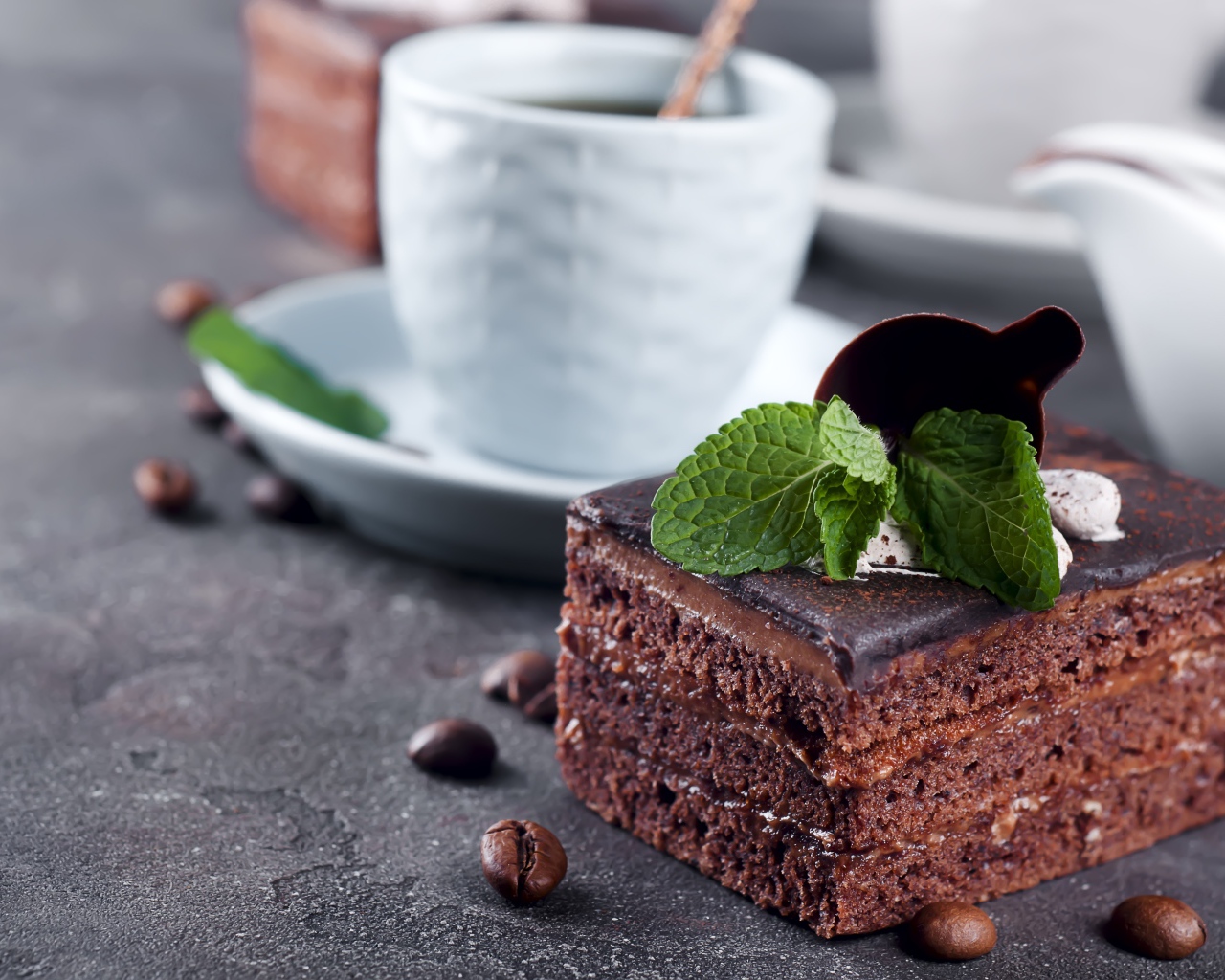 Шоколадное пирожное на столе с чашкой кофе