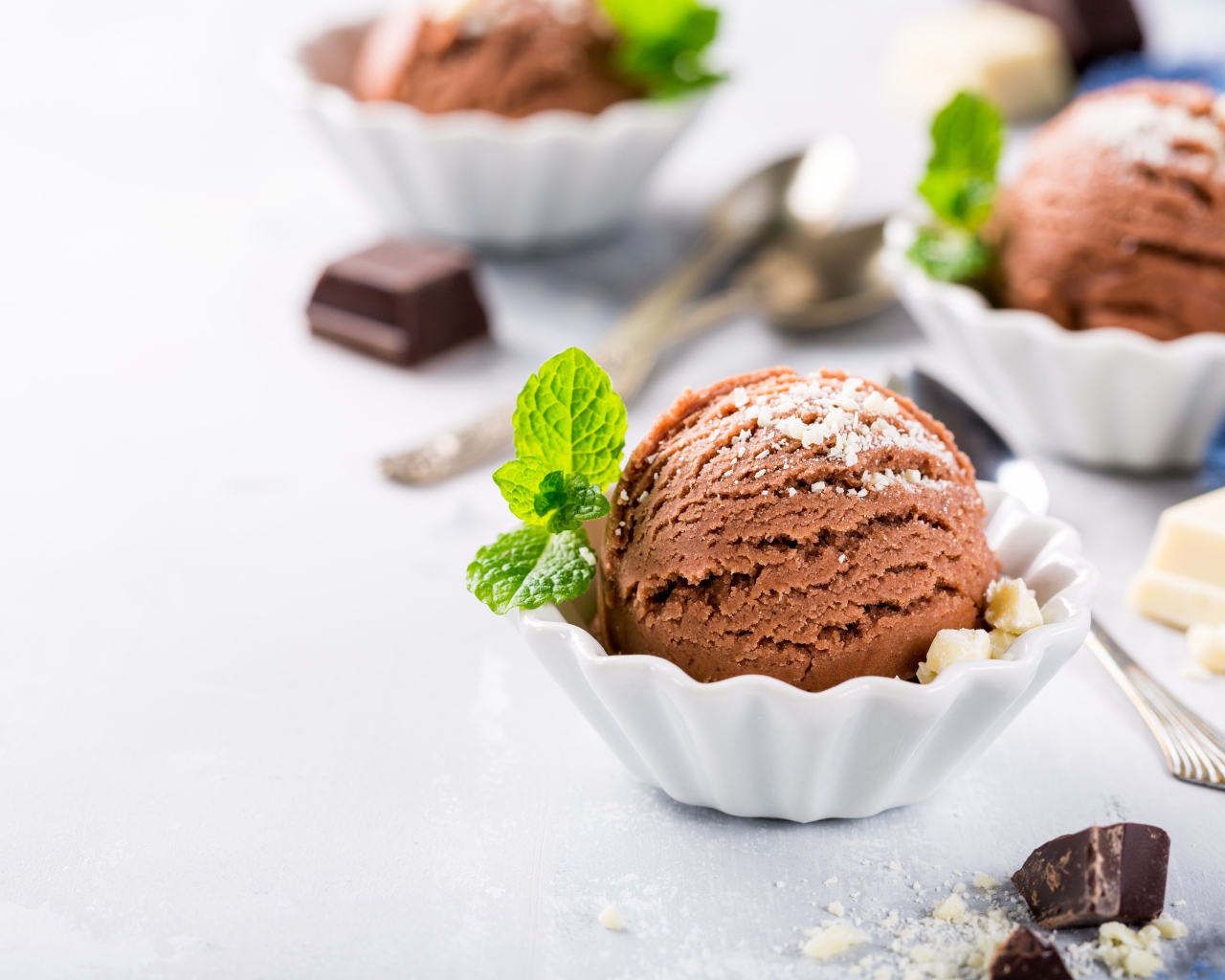 Шарик шоколадного мороженого с мятой на столе с шоколадом
