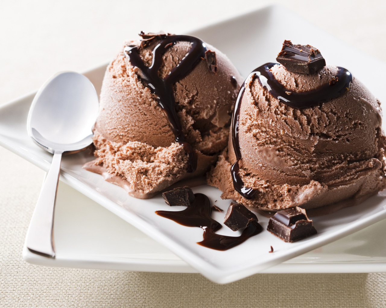 Шарики шоколадного мороженого на белой тарелке
