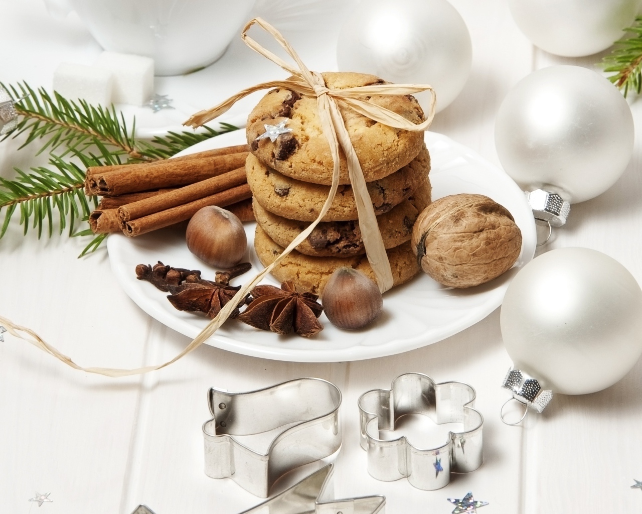 Печенье на тарелке с орехами и корицей на столе с игрушками 