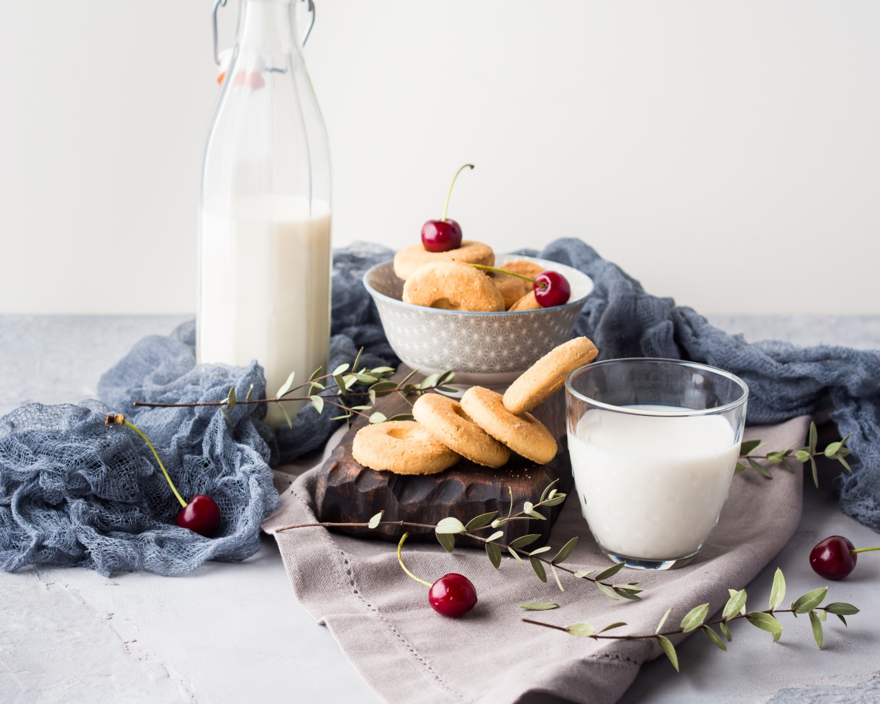Печенье на столе с молоком и черешней