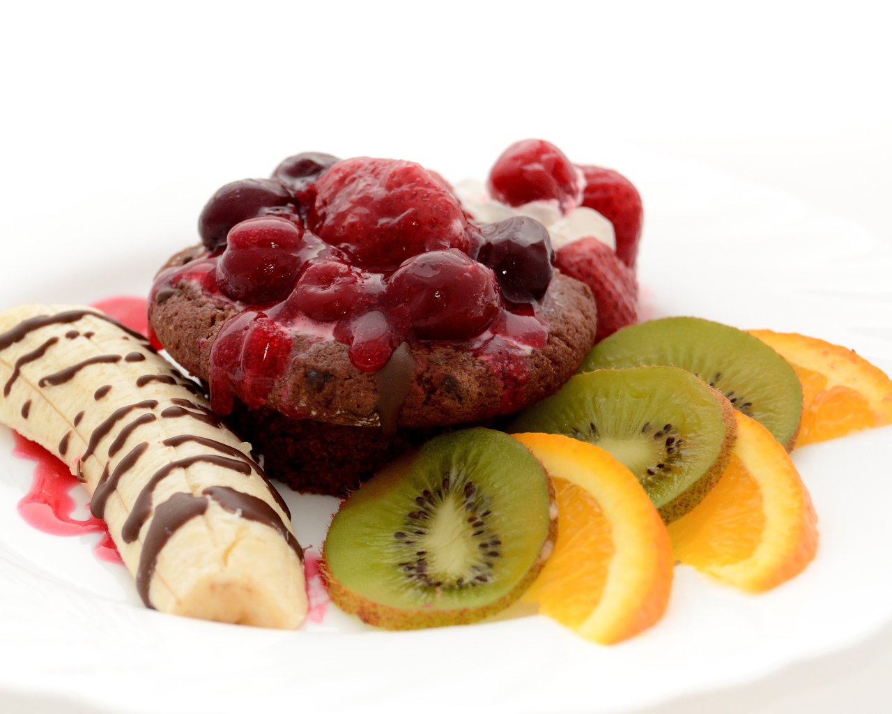 Печенье с вареньем, кусочками банана, киви и апельсина на белом фоне