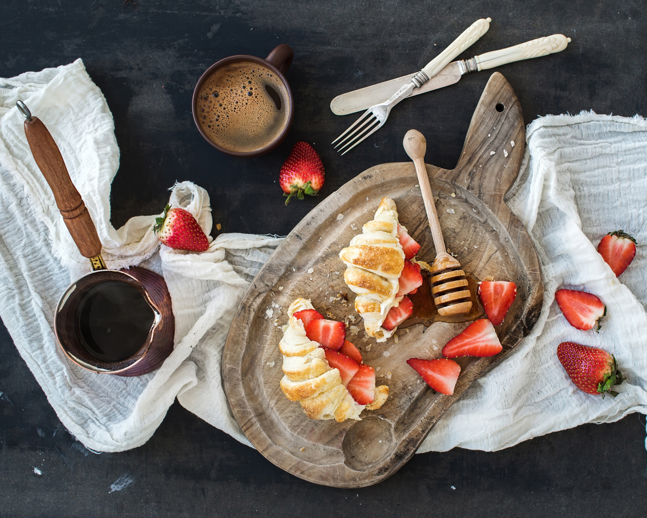 Круассаны на доске с клубникой и медом