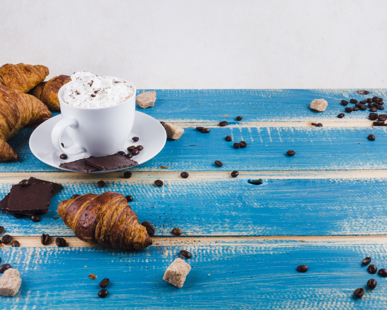 Круассаны на столе с напитком и шоколадом