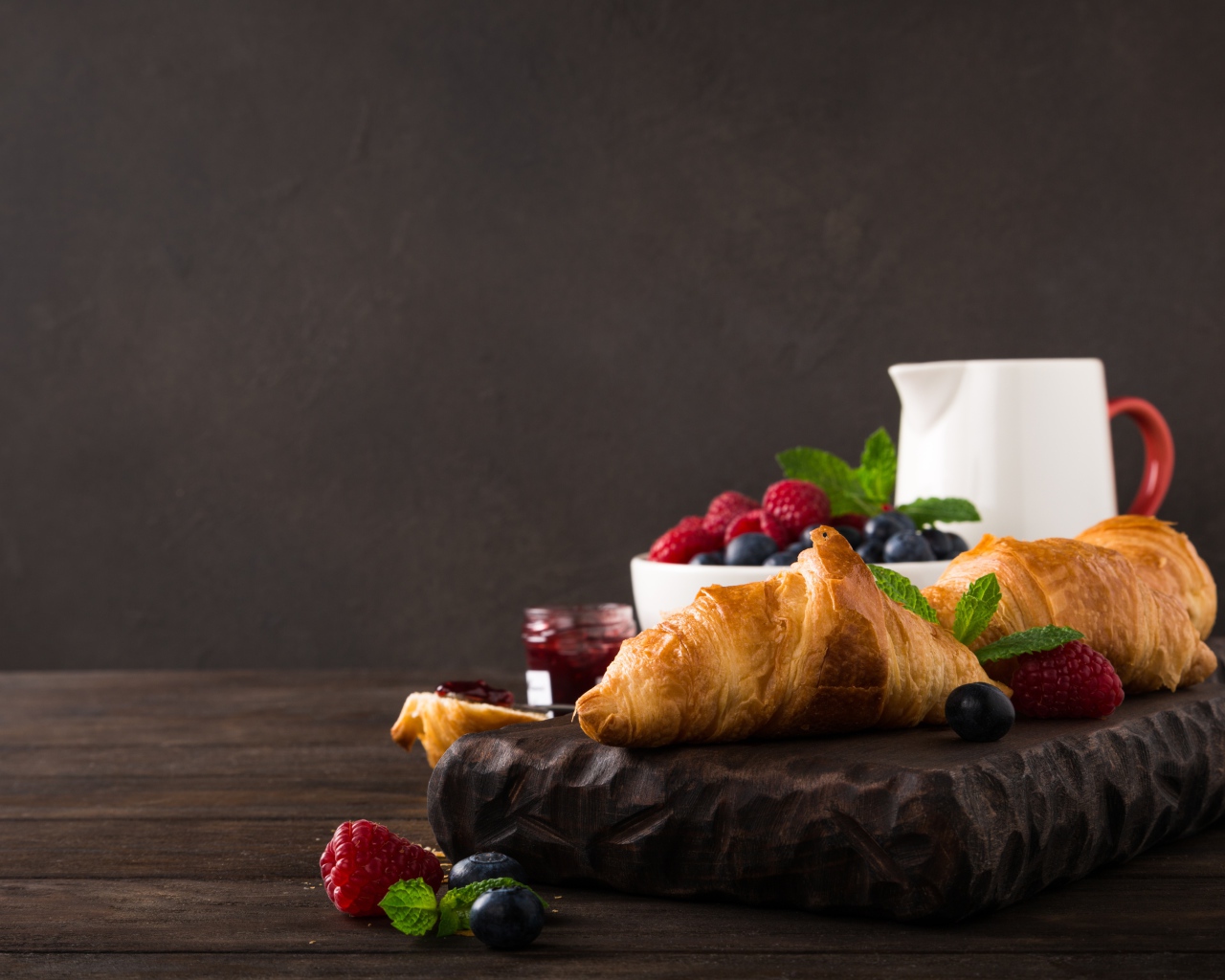 Круассаны на столе с ягодами и джемом 