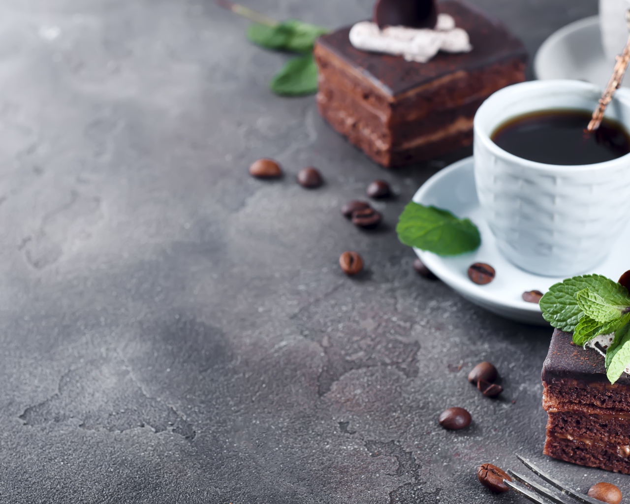 Аппетитное шоколадное пирожное на сером столе с чашкой кофе