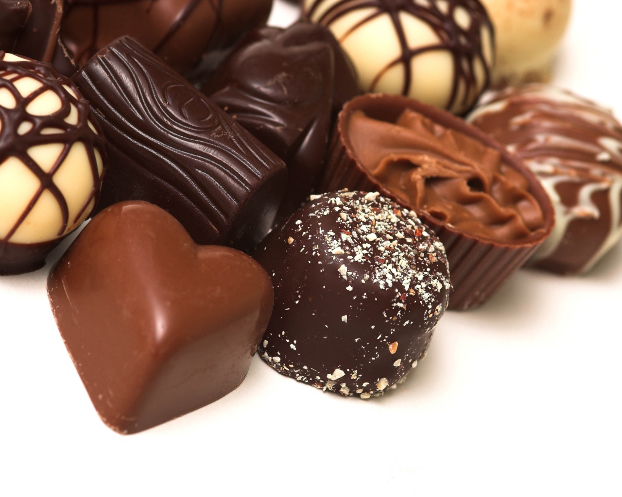 Разные шоколадные конфеты на белом фоне 